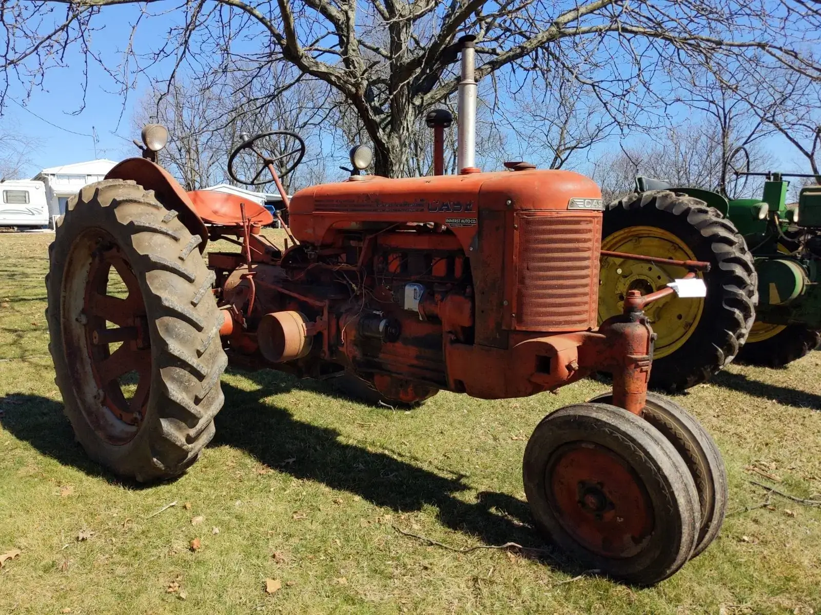 Orange vintage tractor on grassy field.